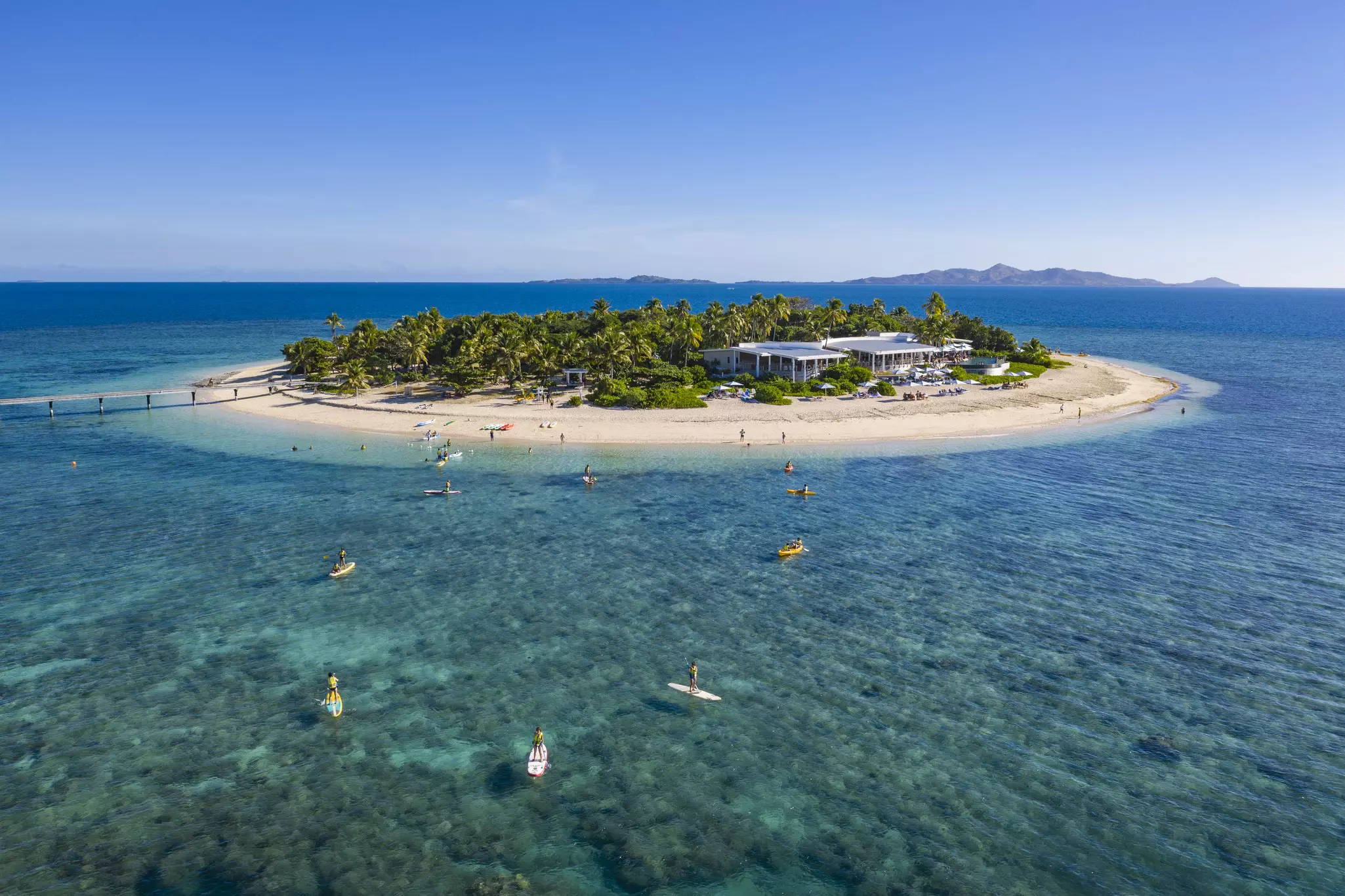 People on paddle boards outside a small island
