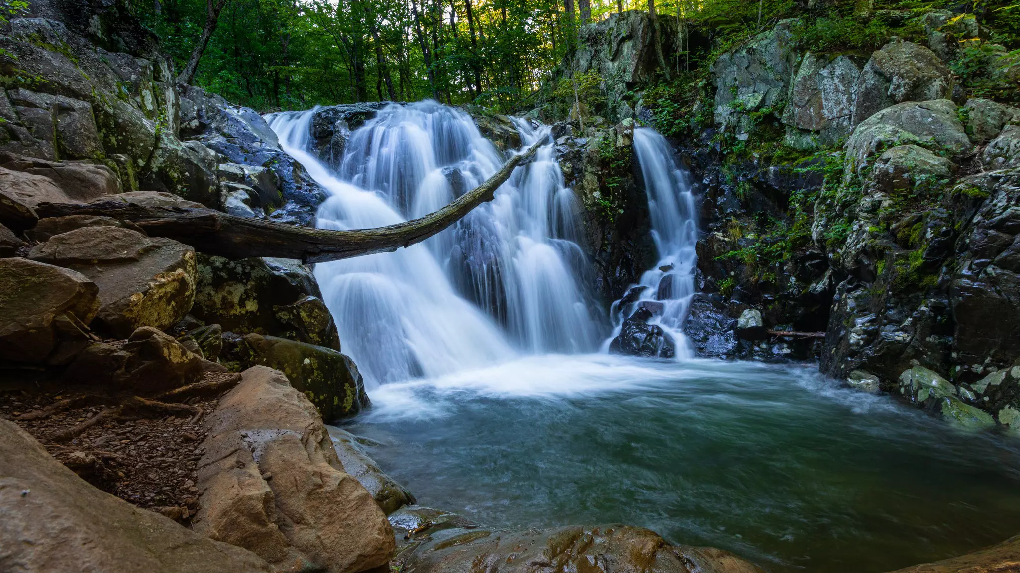 Pool of water with multiple low waterfalls in the background.