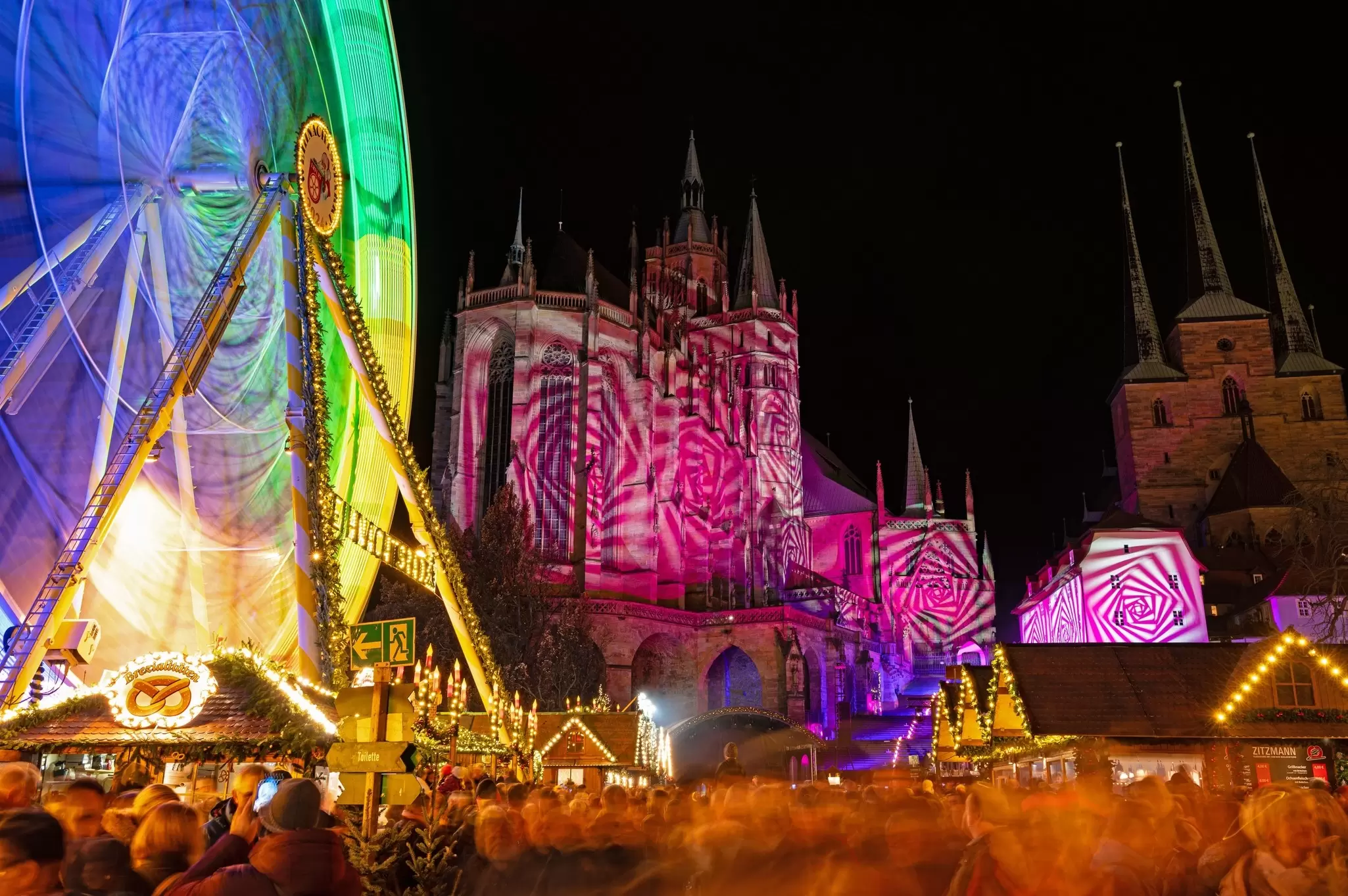 Christmas market at the cathedral square in Erfurt with light show at the cathedral at the opening day.