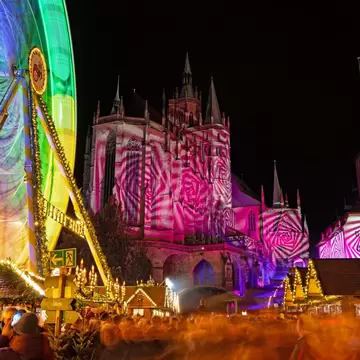 Christmas market at the cathedral square in Erfurt with light show at the cathedral at the opening day.
