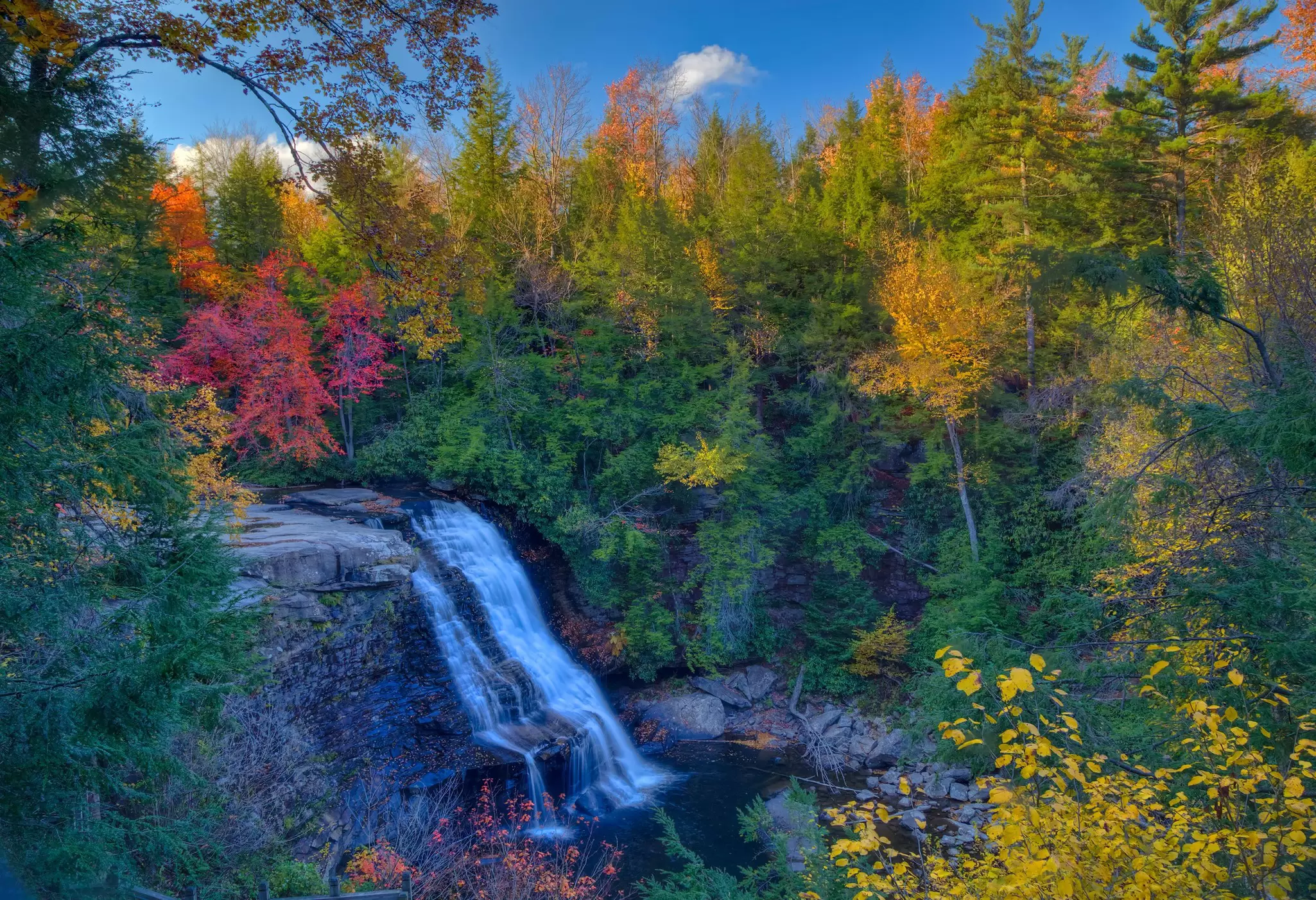 A beautiful waterfall during the fall season with foliage around in Maryland