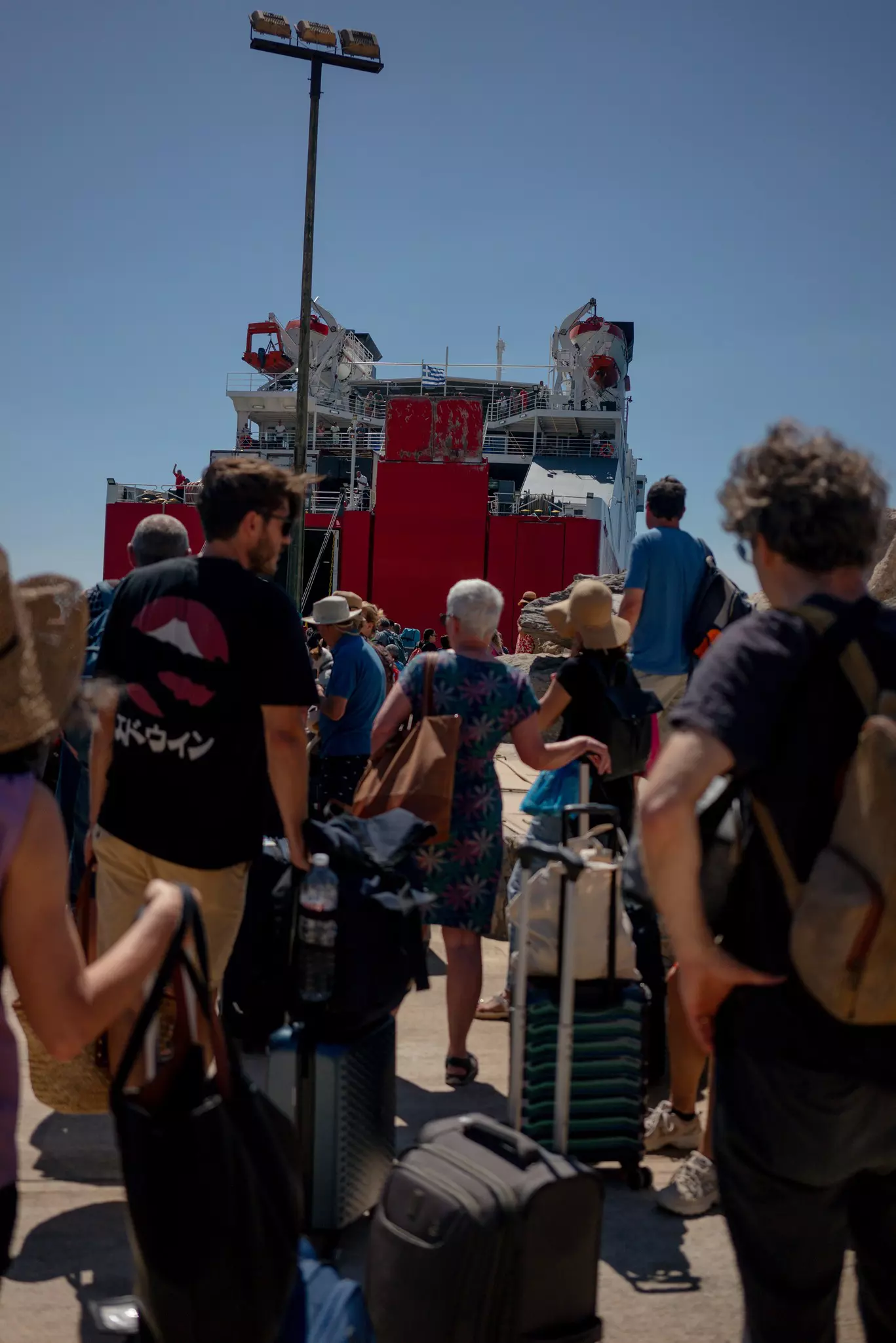 People board the ferry on Sikinos Island with their luggage