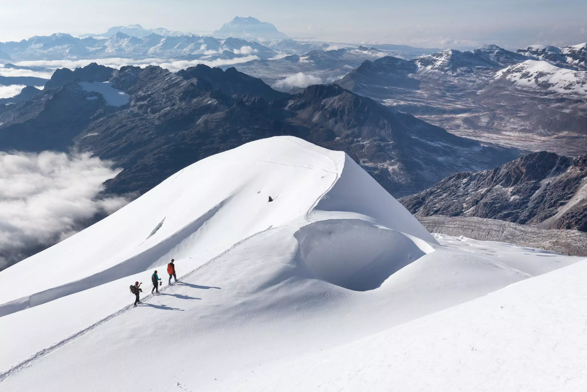 Three mountaineers on a snow ridge