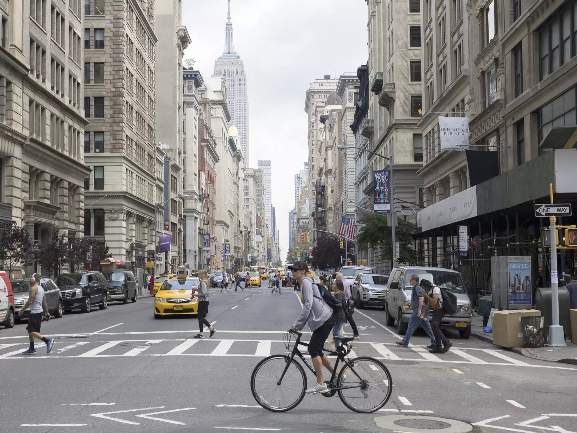 Pedestrians, cabs and cyclists at the intersection of Fifth Ave and 18th St in NYC.