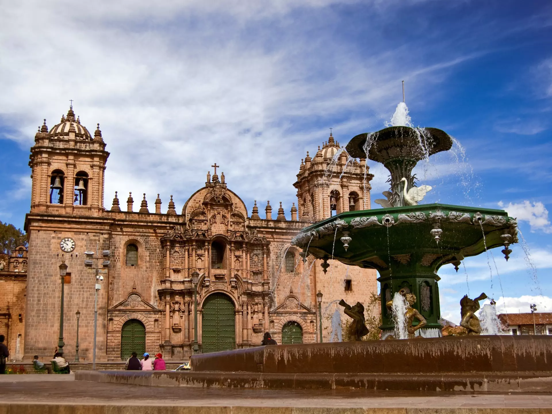 A large fountain and elaborate stone cathedral.