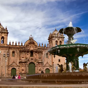 A large fountain and elaborate stone cathedral.