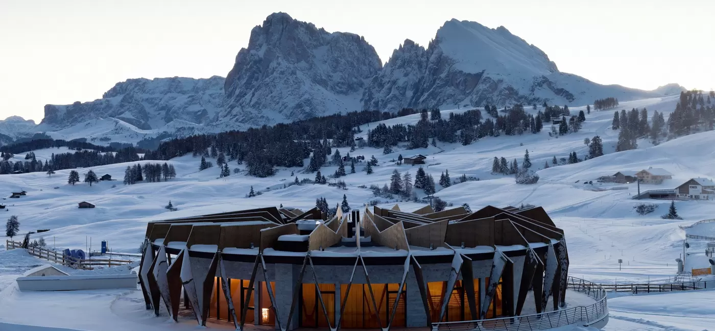 A round low-rise building in the middle of a snowy landscape: COMO Hotels & Resorts, the Dolomites, Italy