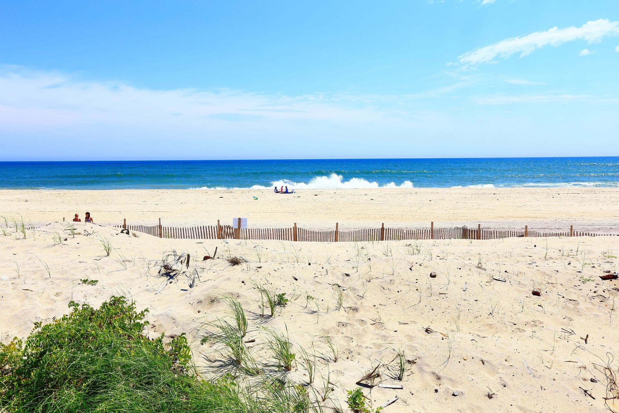 A group of people on empty sandy beach.