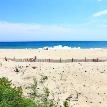 A group of people on empty sandy beach.