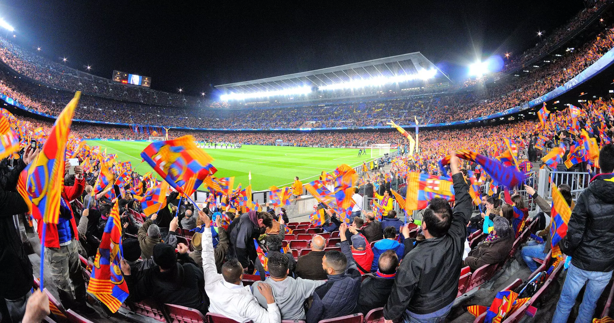 Soccer fans watch a game while waving colorful flags