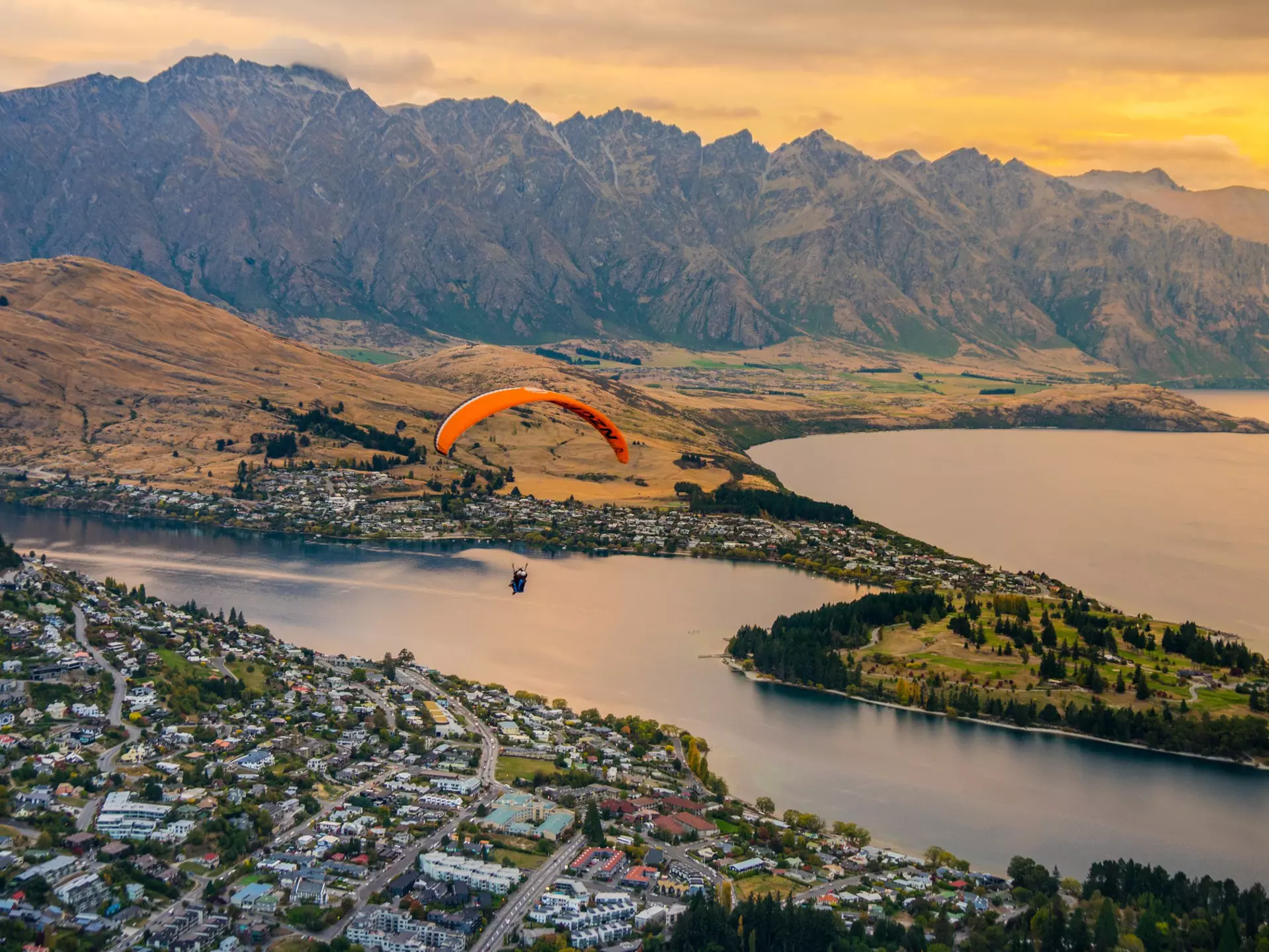 Paragliding over Queenstown at sunset. Puripat Lertpunyaroj/Shutterstock