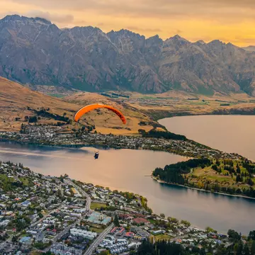 Paragliding over Queenstown at sunset. Puripat Lertpunyaroj/Shutterstock