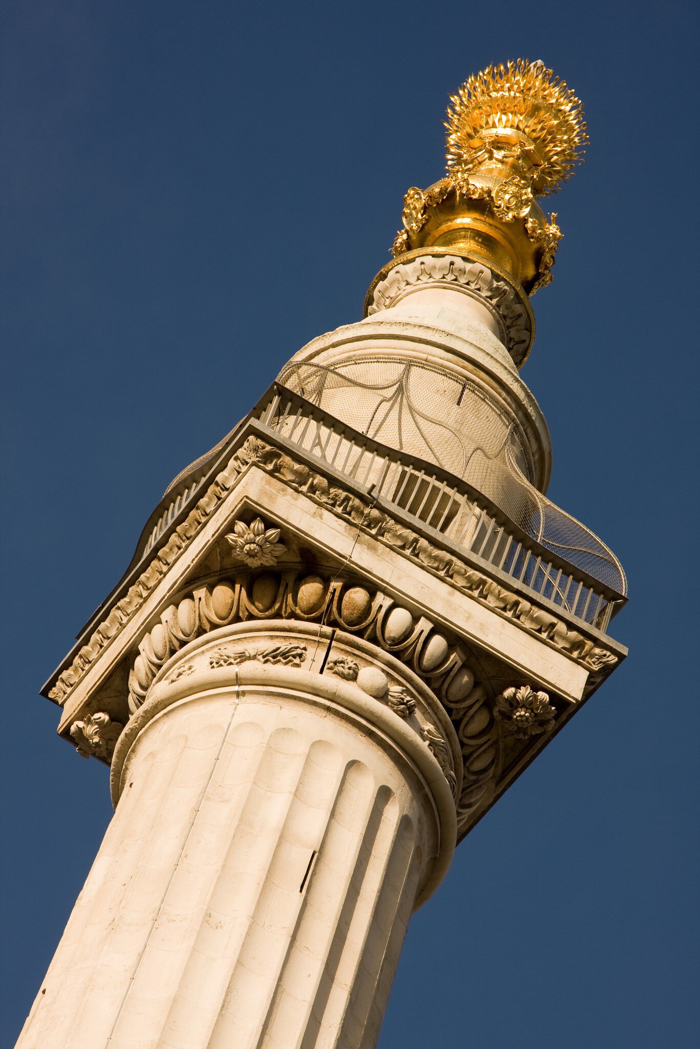 A close-up of the top of 'The Monument' in London, UK.