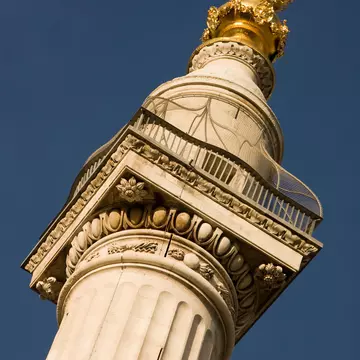 A close-up of the top of 'The Monument' in London, UK.