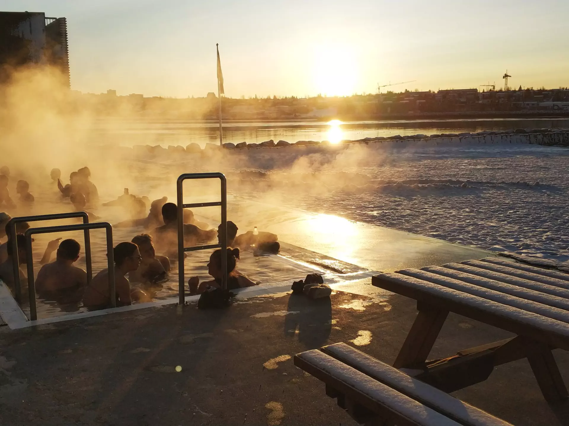 A group of people surrounded by steam in a geothermal pool in Reykjavik, Iceland.