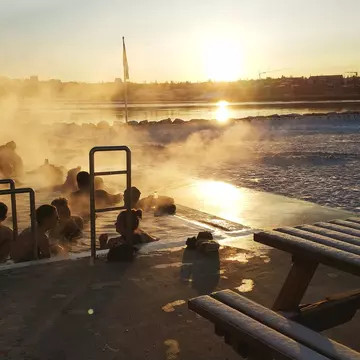 A group of people surrounded by steam in a geothermal pool in Reykjavik, Iceland.