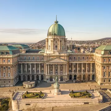 Aerial shot of the front facade of Buda Castle (also known as the Royal Palace) during sunrise in Budapest, Hungary.