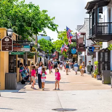 People walking and shopping on St George Street in St Augustine on summer day by stores shops and restaurants in old town Colonial quarter