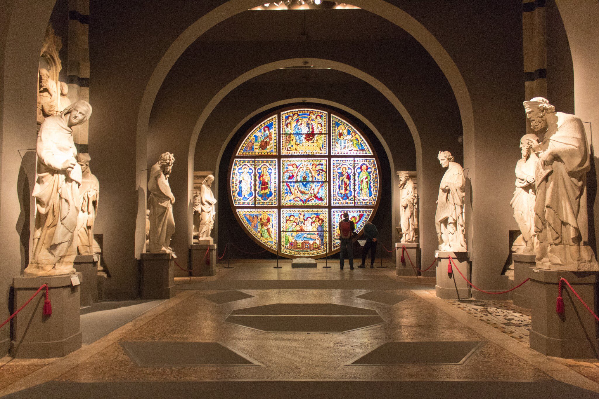 Visitors admire the stained glass windows inside the Museo dell'Opera metropolitana at Siena Cathedral.