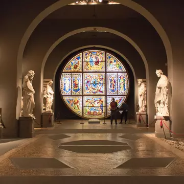 Visitors admire the stained glass windows inside the Museo dell'Opera metropolitana at Siena Cathedral.