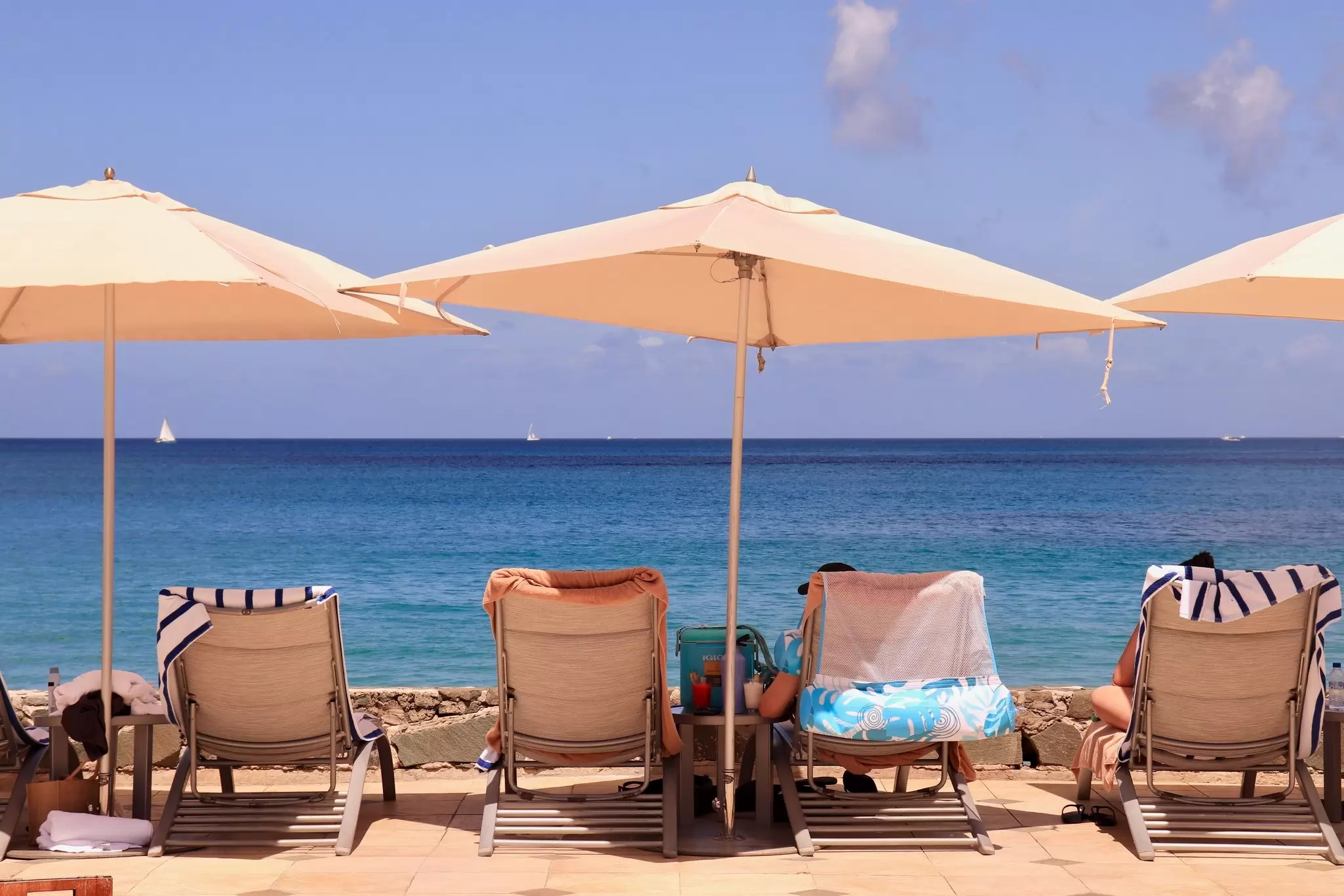 Sun loungers under umbrellas facing the sea.