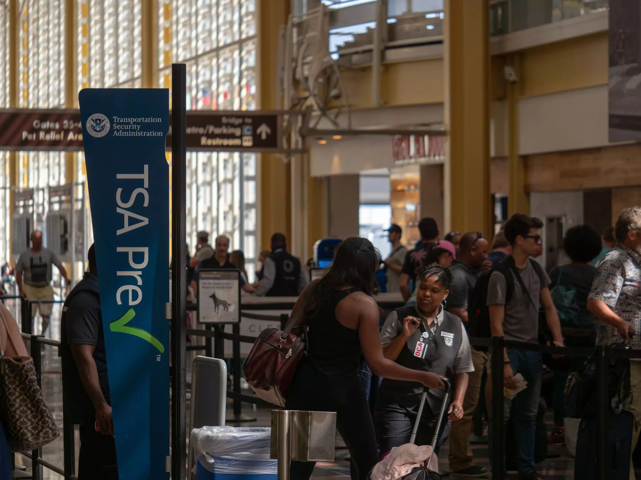 A woman having her documents checked at a TSA checkpoint at an airport