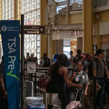 A woman having her documents checked at a TSA checkpoint at an airport
