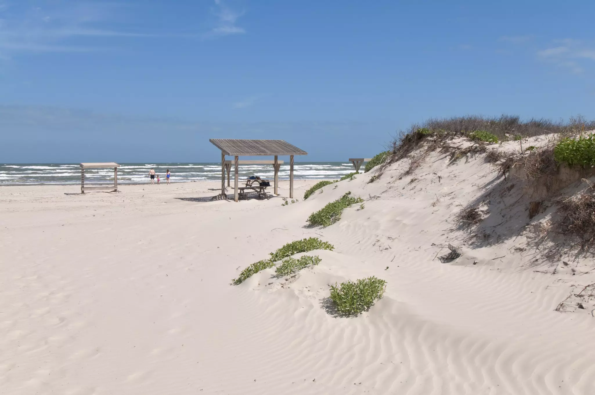 Malaquite Beach, Padre Island National Seashore, with a man, woman and child in the background near the water