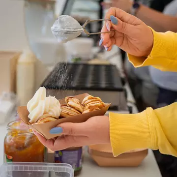 Dutch Mini Pancakes Poffertjes. Fluffy mini pancakes that are served with a mess of powdered sugar and whipped cream. Dutch poffertjes - tiny pancakes- being prepared during street food festival., License Type: media, Download Time: 2025-12-12T11:49:11.000Z, User: pinkjozie64, Editorial: false, purchase_order: 56530 - Guidebooks, job: Global Publishing WIP (for books) , client: amsterdam 14, other: Jo-anne Riddell