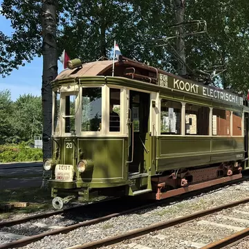 View of a historic green tram of the Electrische Museumtramlijn Amsterdam on a sunny day.