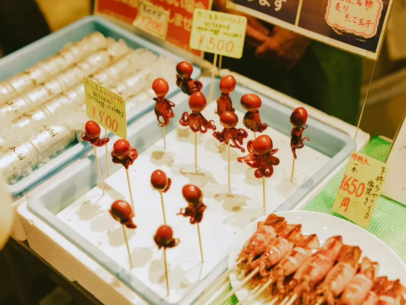 A tray of tiny octopuses on wooden sticks