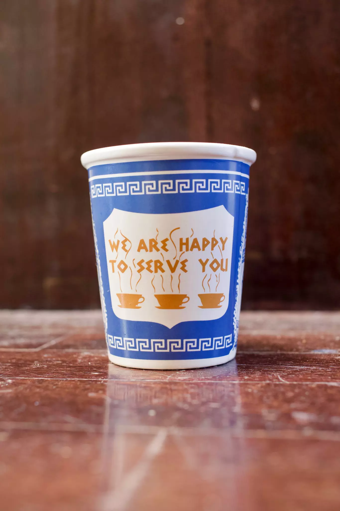 NYC's famous blue to-go coffee cup. Anthora cup on rustic dark brown wood background.