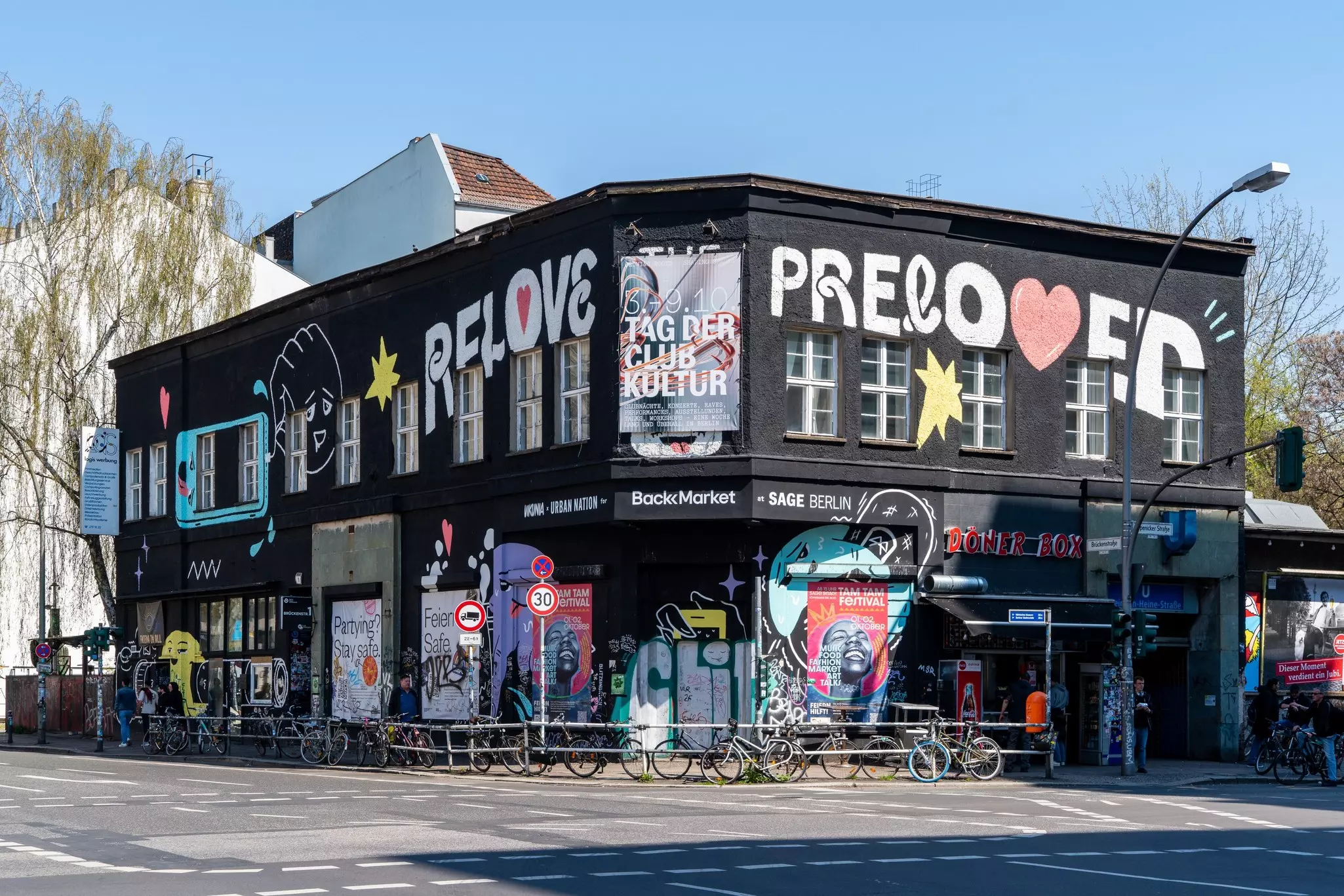 Black painted building on a city street corner on a sunny day.