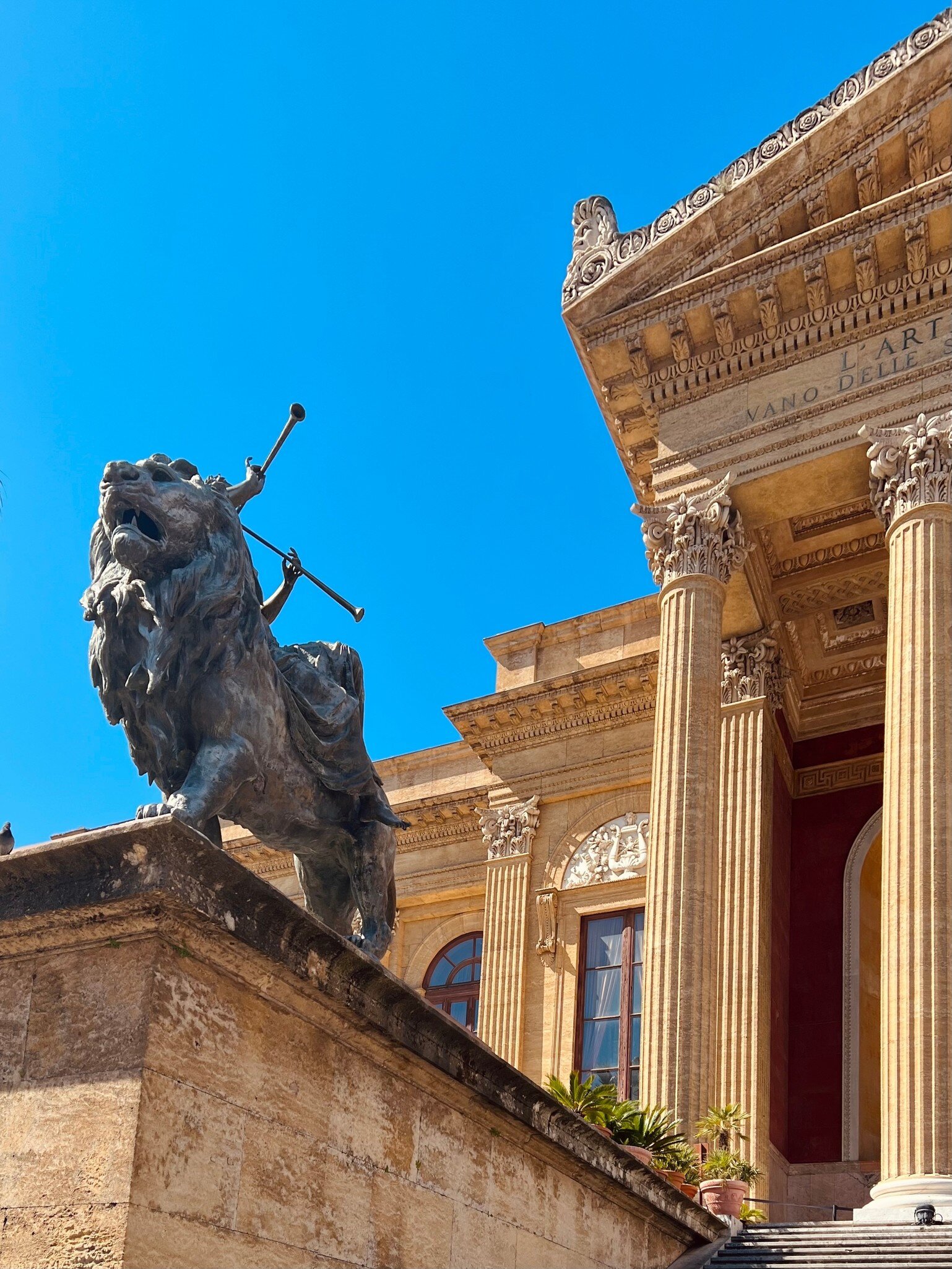 Front of the Teatro Massimo with a lion statue.