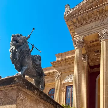 Front of the Teatro Massimo with a lion statue.