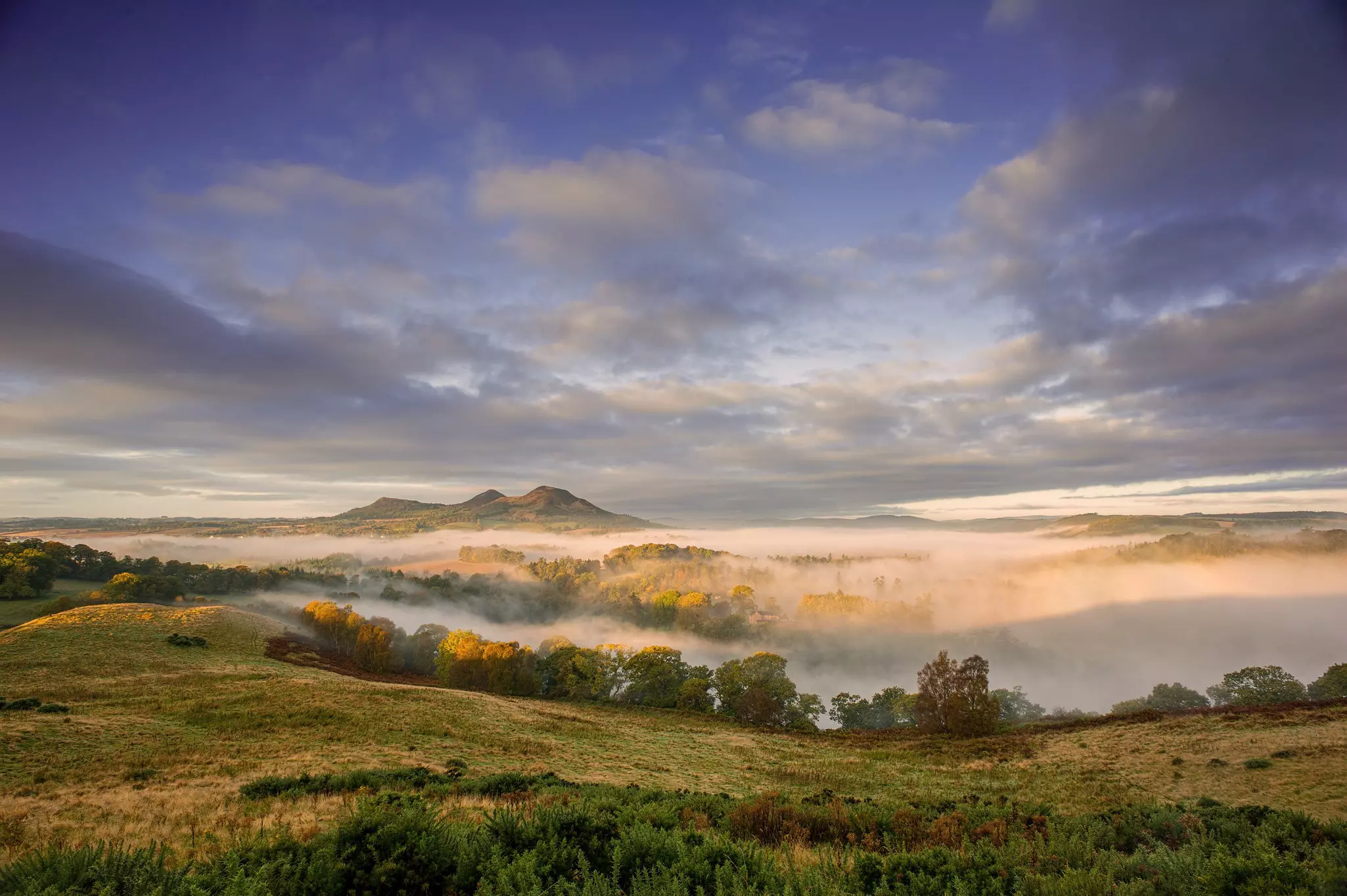 Morning mist surrounds Eildon Hill in the Scottish Borders, Scotland.