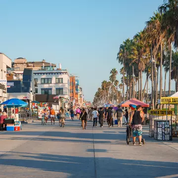 People walk and cycle along the Venice Beach Boardwalk in Los Angeles, California, USA.
