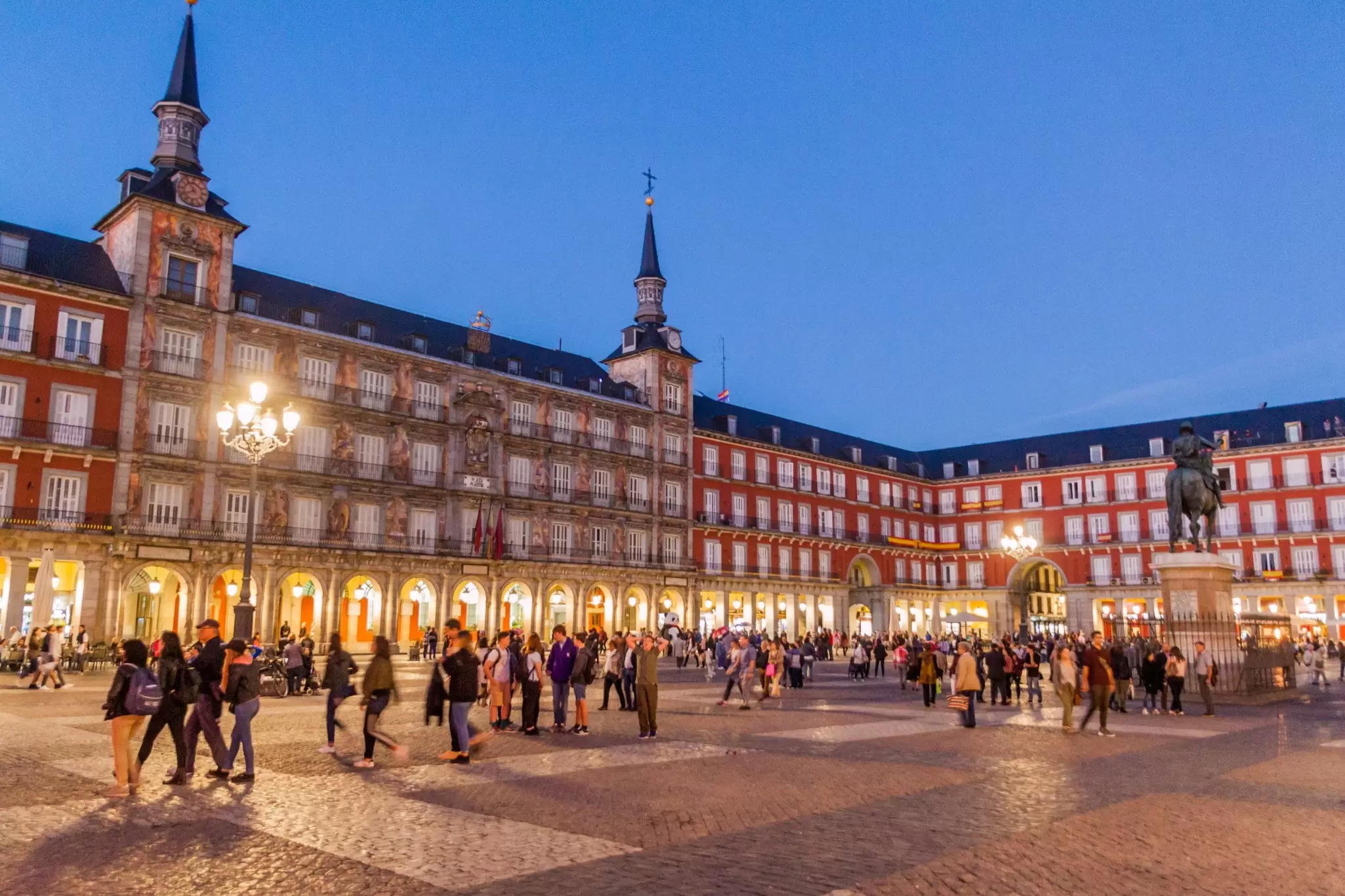 People walking in the evening light in Plaza Mayor in Madrid, Spain.