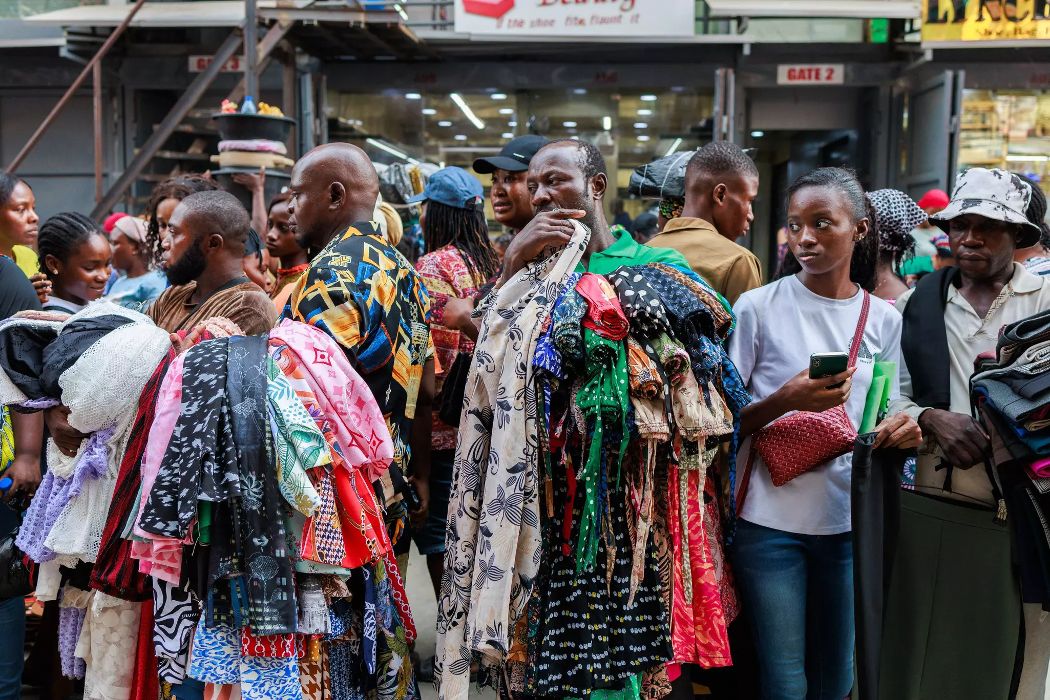 Sellers look for costumers while selling clothes at the Balogun Market in Lagos on December 18, 2023. Christmas and year-end celebrations are marred by the economic crisis and soaring prices in Nigeria. Poverty in the most populous country in Africa has risen in 2023, affecting 104 million people, compared to 79 million five years earlier, according to the World Bank. The prices of food items and basic goods have skyrocketed following an increasing inflation rate and devaluation of the Naira, making daily life increasingly difficult for millions of Nigerians.