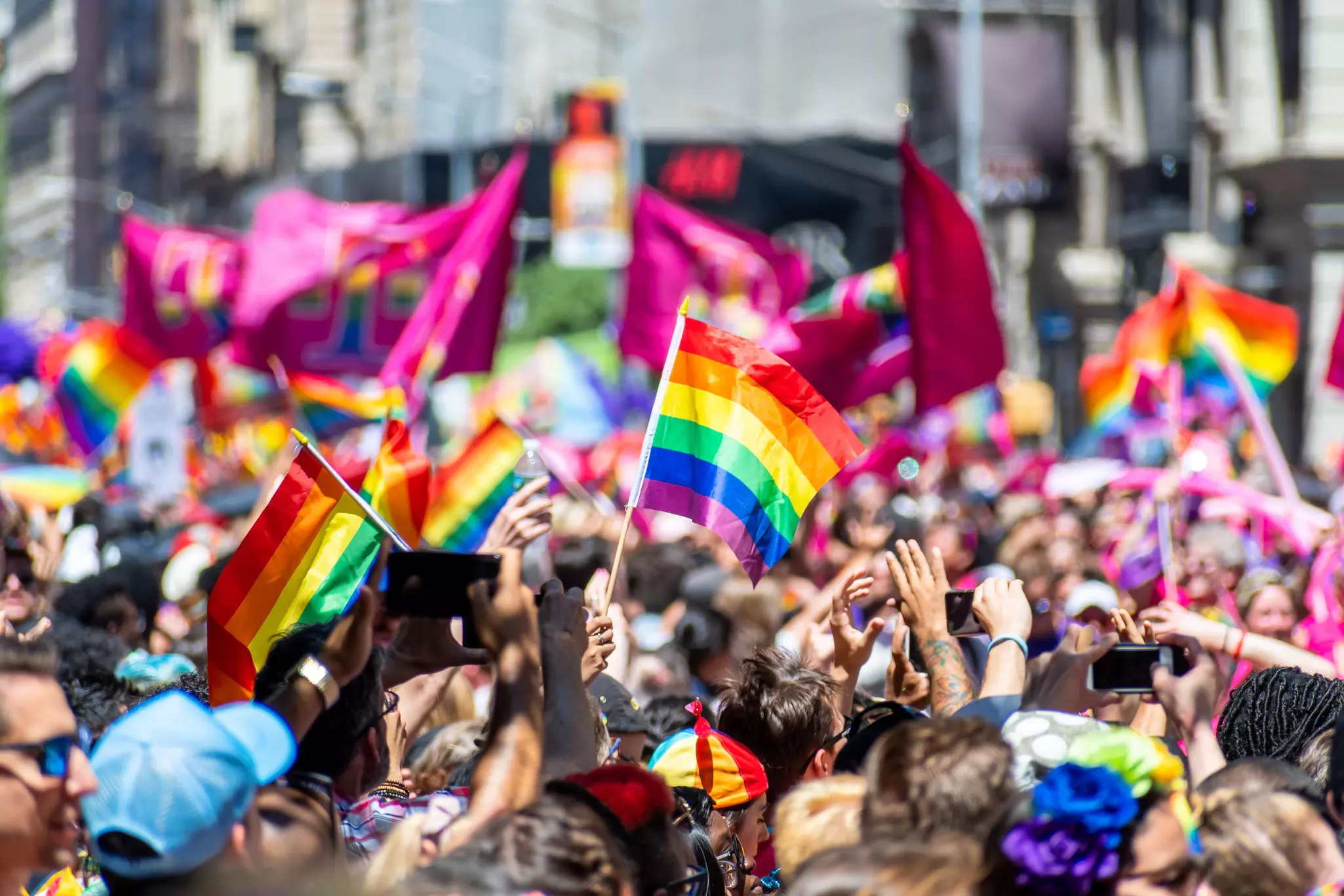 Thousands of people wearing colorful costumes attending the World Pride March in NYC for LGBTQ+ rights.