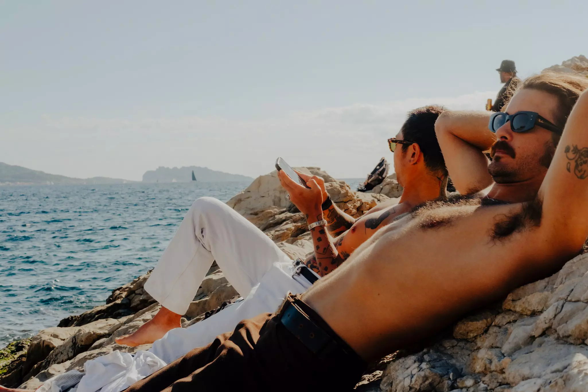 Scenes around Marseille, France, men sunbathing by the sea