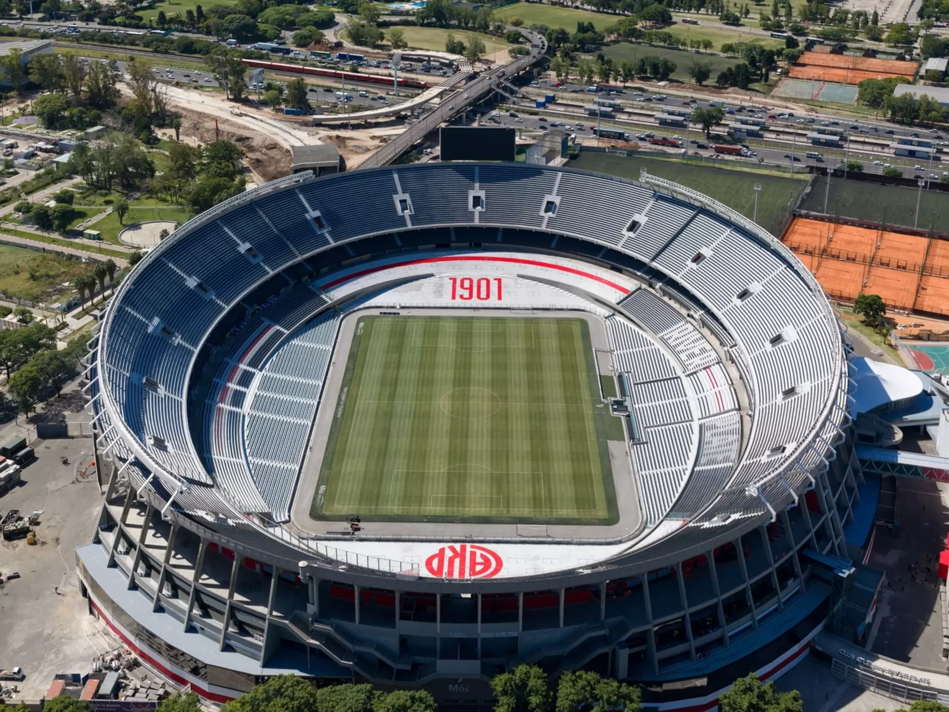 Aerial view of a soccer stadium in Buenos Aires with the city and water around it. 