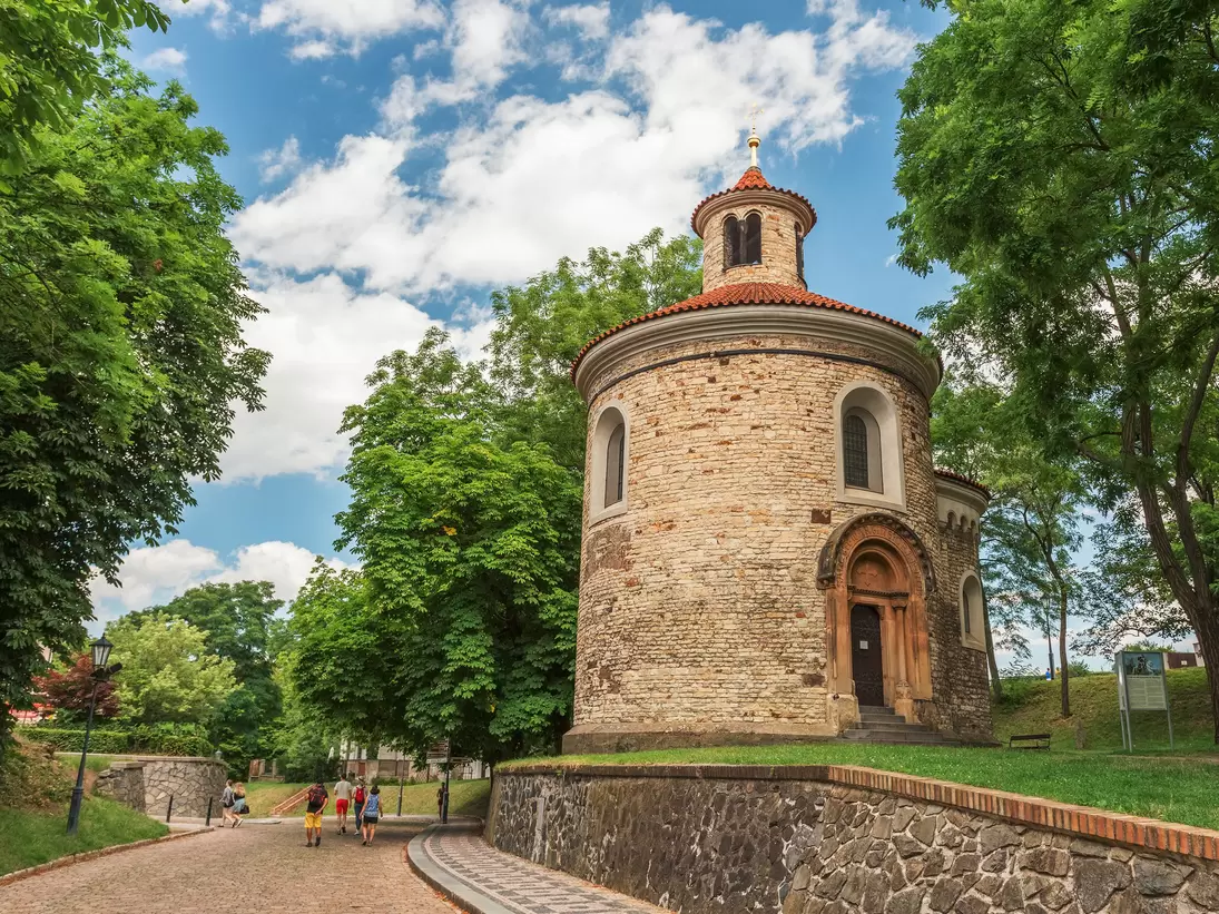 St. Martin rotunda, Vysehrad, Prague, Czech Republic. People walking to the left and blue cloudy sky above. 