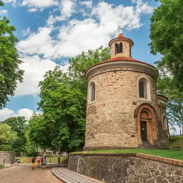 St. Martin rotunda, Vysehrad, Prague, Czech Republic. People walking to the left and blue cloudy sky above. 
