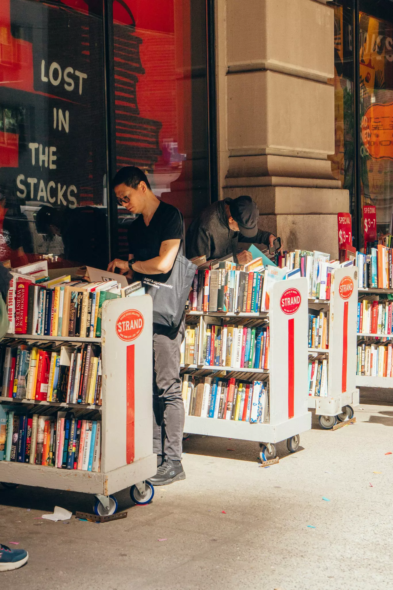 Shoppers browsing books outside Strand Book Store, Manhattan, New York City.