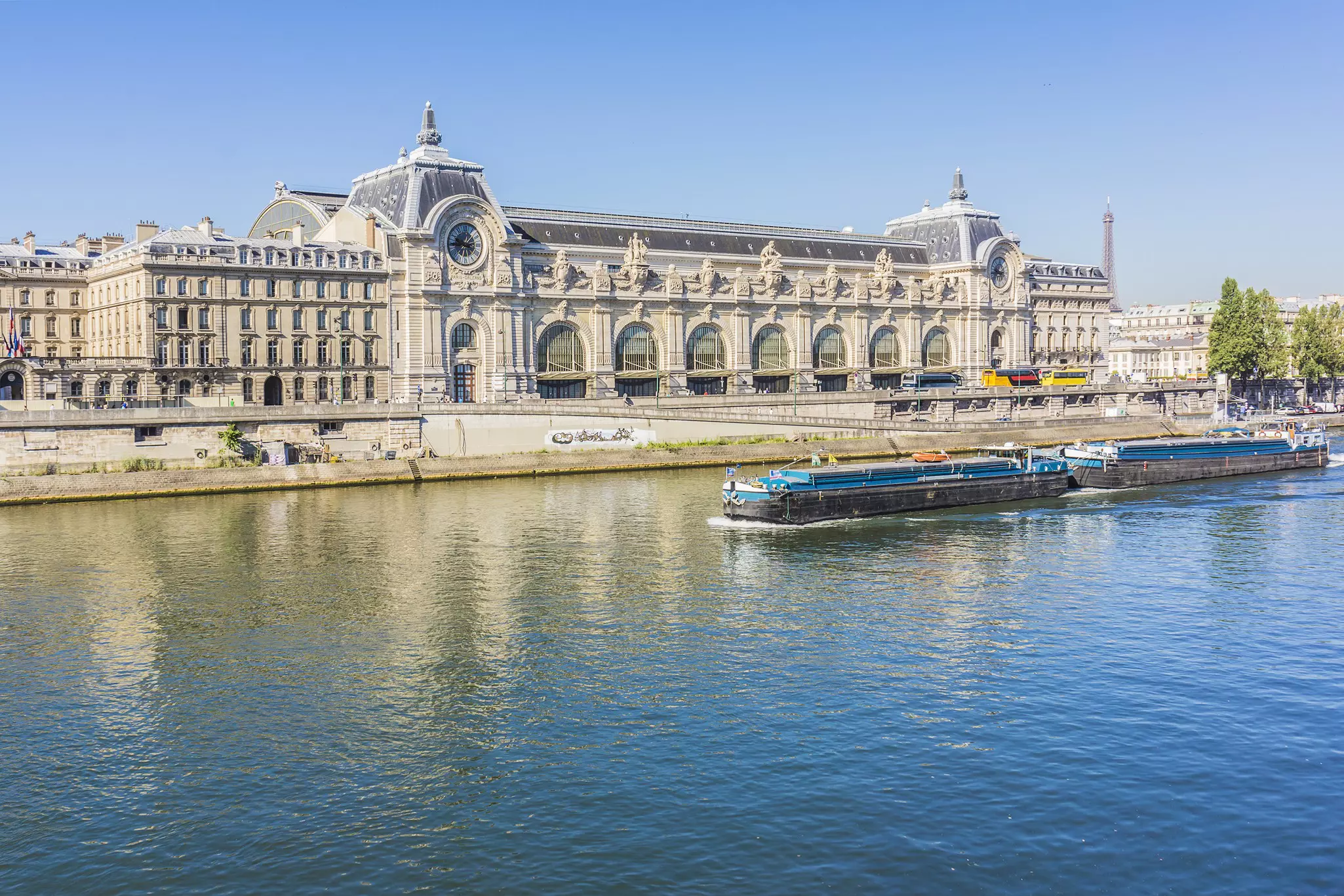 A view of an elaborate art nouveau building alongside a river in a city.