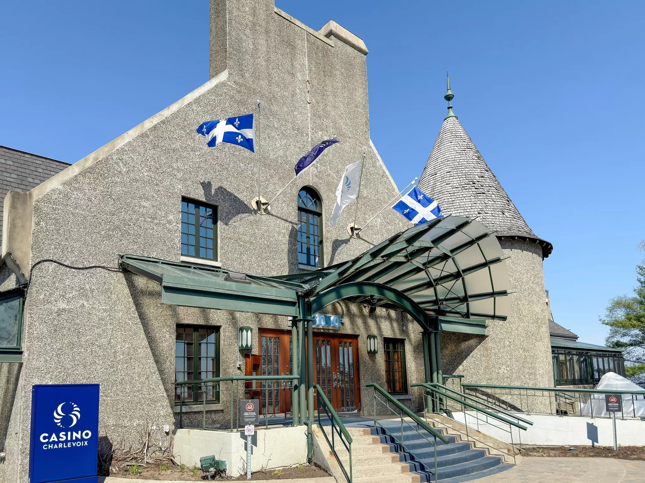 Blue and white flags flying over the entrance to a large stone building