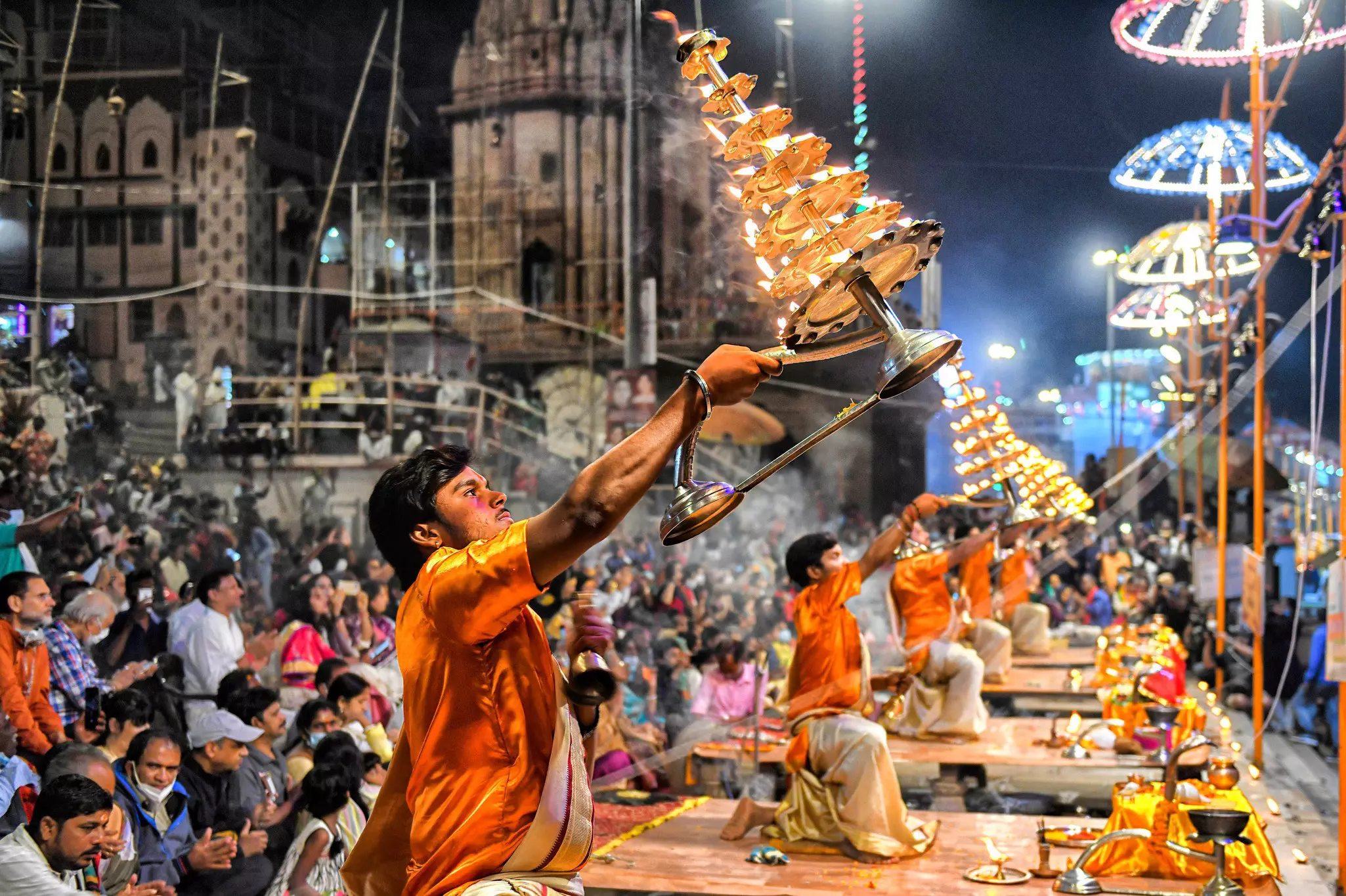 Hindu Priests performing evening prayers with many lit candles
