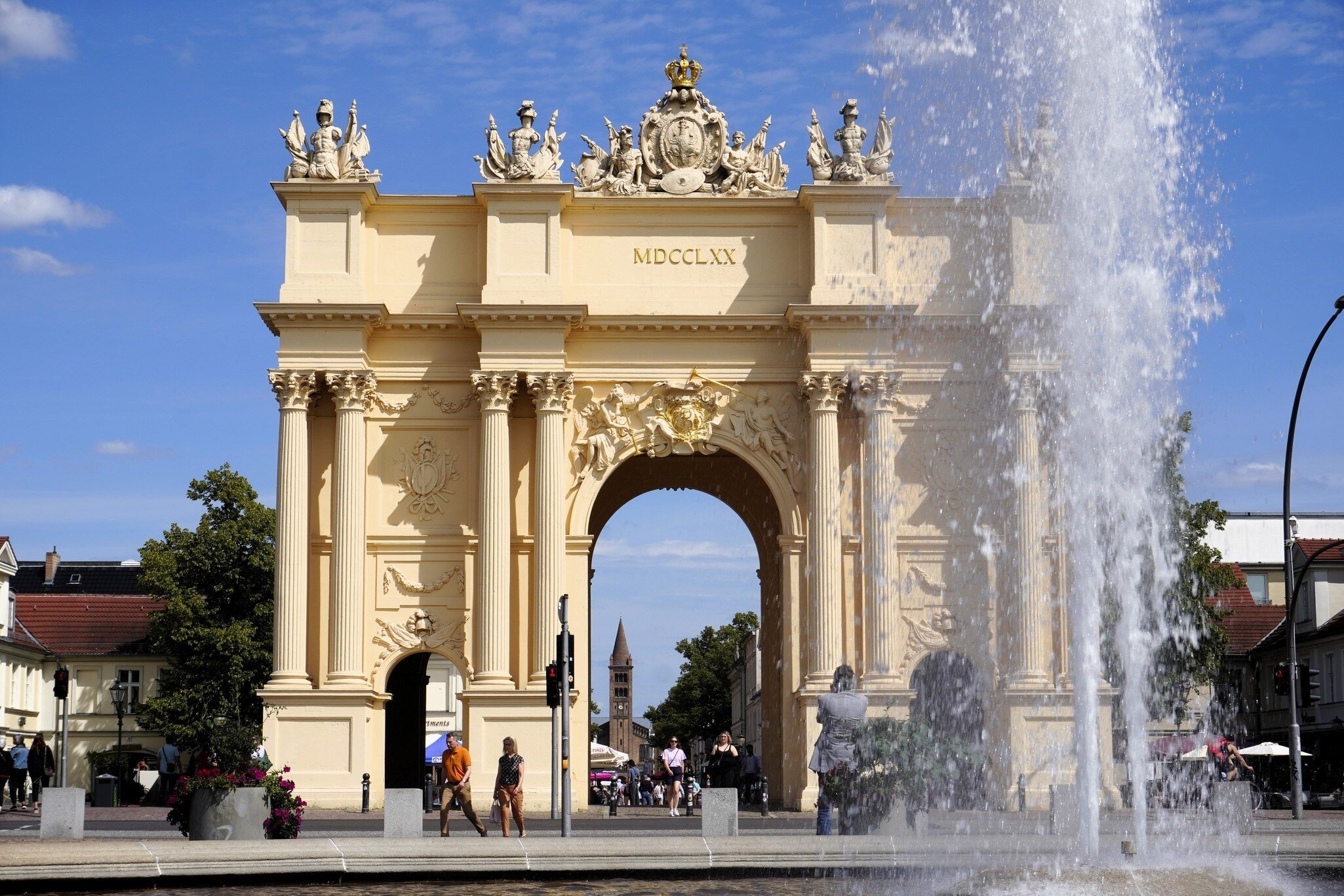View of three landmarks in the historic Potsdam old town: Luisenplatz water fountain, Brandenburg Gate, and Peter and Paul Church in Potsdam, Germany.