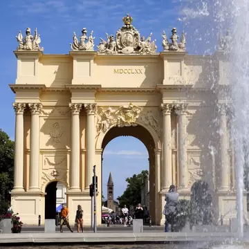 View of three landmarks in the historic Potsdam old town: Luisenplatz water fountain, Brandenburg Gate, and Peter and Paul Church in Potsdam, Germany.